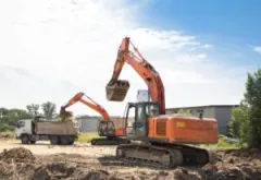 Two excavators work on a construction site.