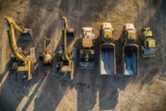 Construction equipment lined up in a row and viewed from overhead.
