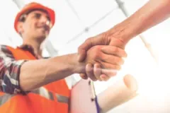 A construction worker shaking hands. Find out how long it takes to resolve a construction accident claim with our team.