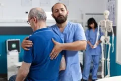 A medical professional feels for damage in a patient’s spine after an accident.