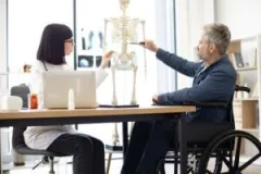 A doctor and patient discussing a spinal cord. Build a legal claim with a spinal cord injury lawyer in Speedway, Indiana.
