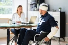 A female personal injury lawyer helps an injured man seek compensation for his traumatic brain injury.