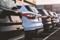 A rear view of several cars parked in a row.