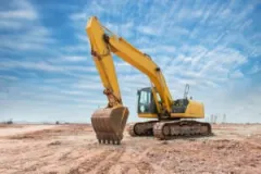 A clawed excavator sits unattended on a construction site.