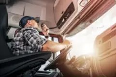 A male truck driver talks over his radio.