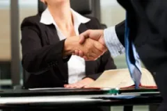 A man shaking hands with a lawyer. Learn how to find the best personal injury lawyer today.