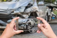 A person taking pictures after a collision. Find out how to build a case with an Evansville car accident lawyer.