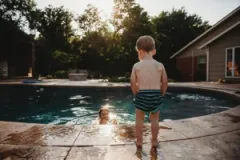 A toddler stands at the edge of the pool while a man swims. If the man swimming in the pool is involved in a drowning accident and is severely injured, or if the toddler falls in the pool and is involved in a drowning incident, family members could file a claim.