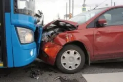 A car and a bus suffer severe damage after a head-on collision.