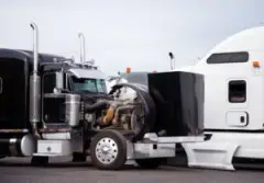 Two semi-trucks sustain serious frontal damage after an accident.