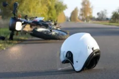 A motorcycle and helmet on the road after a crash. A Valparaiso motorcycle accident lawyer can help you secure compensation for your losses.