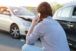 A man on the phone after a crash, asking a lawyer what happens if your Lyft is in an accident. 