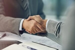 A car accident victim shakes hands with an insurance adjuster on a fair settlement offer. The injured victim knew how to negotiate with The General Insurance Company.