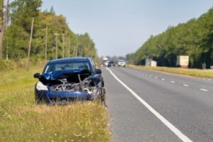 A car rests on the side of the road after an accident on the interstate.