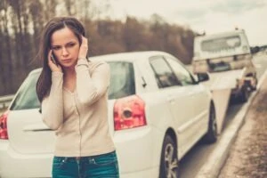 Woman talks on phone while car is towed after US 30 accident in Indiana.