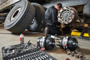 A mechanic services a truck’s brakes.