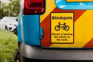 A close-up of a blindspot sign on the back of a commercial vehicle.