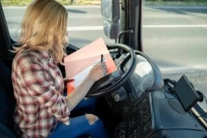 A trucker fills out paperwork to comply with compliance, safety, and accountability (CSA) requirements.