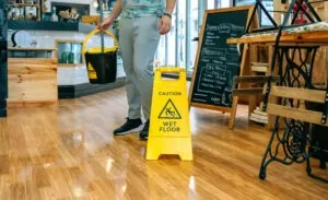 worker placing wet floor sign