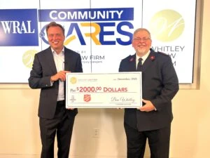 Attorney Ben Whitley presents a check for $2,000 to Major Chuck Whitten of The Salvation Army at WRAL studios