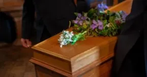 pallbearers carrying the casket at a funeral of a deceased worker