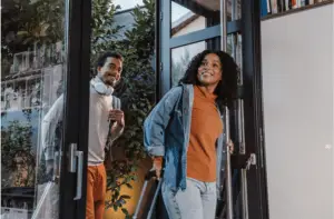 A man and a woman entering through a door