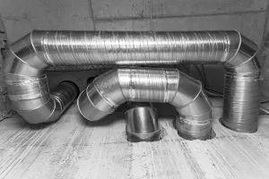 aluminum air duct system entering concrete wall and floor