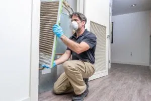 HVAC maintenance technician removing dirty air filter