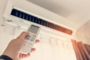 person using remote to control AC