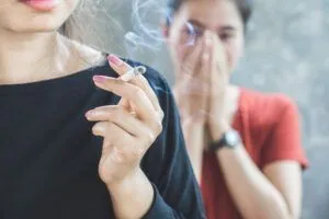 woman smoking near other woman