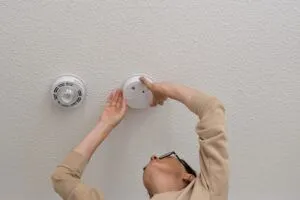 man installing carbon monoxide detector