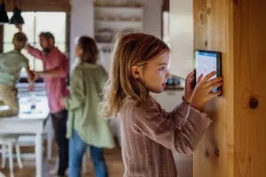 child trying to turn on thermostat in her house