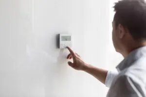 man adjusting air conditioner control panel