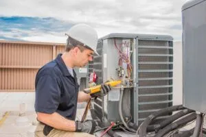 technician working on an outdoor air conditioning unit