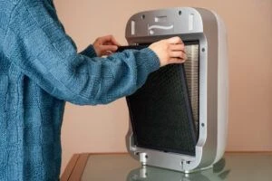 person changing filter in portable air conditioner