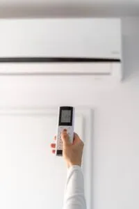 person operating air conditioner with a remote