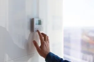 woman adjusting thermostat