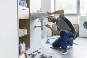 plumber unclogging a sink drain