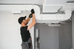 An HVAC technician working on a system. Is a high SEER rating important for your home’s HVAC?