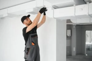 An HVAC technician working on a system. What is a good SEER rating for your air conditioner?