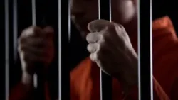 Desperate criminal holding jail bars feeling regret for committing crime closeup.