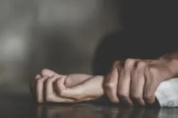 Man's hand holding a woman hand for rape and sexual abuse concept.