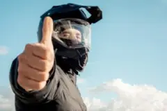 a man in a motorcycle helmet giving a thumbs-up