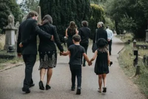 Parents and children walk home from a funeral. A lawyer can tell them what's the average settlement for a wrongful death in Virginia.