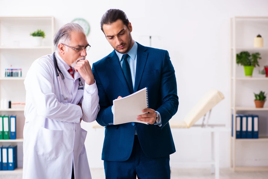 A doctor and a Texas medical license defense lawyer review paperwork during a consultation