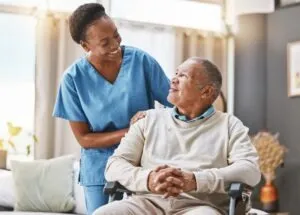 Nurse helps patient in wheelchair after maintaining nursing license