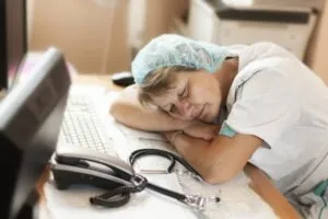 Nurse in scrubs sleeps on the job risks disciplinary action.