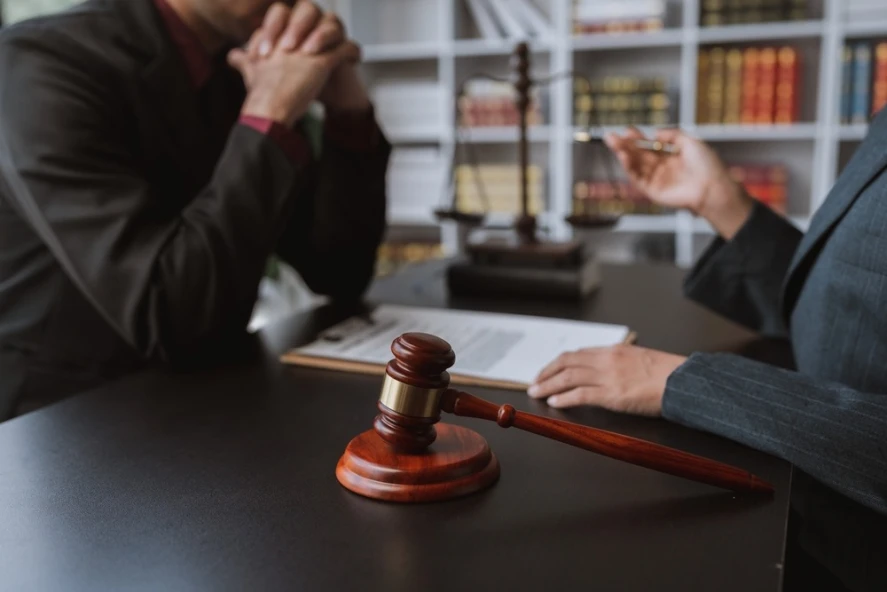 A client sits across the desk from an attorney after hiring a CPA license defense lawyer.