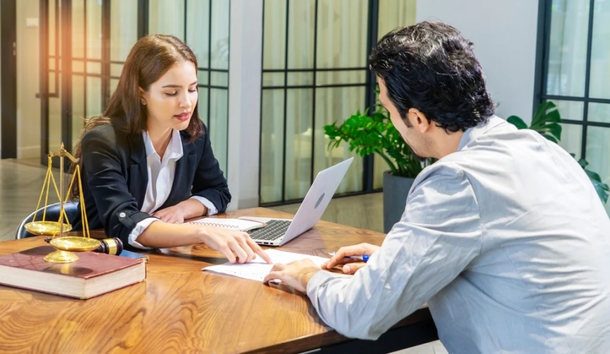 A physician license defense lawyer sitting at her desk with a client discussing legal options.