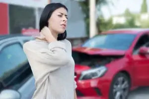woman massaging neck pain after accident